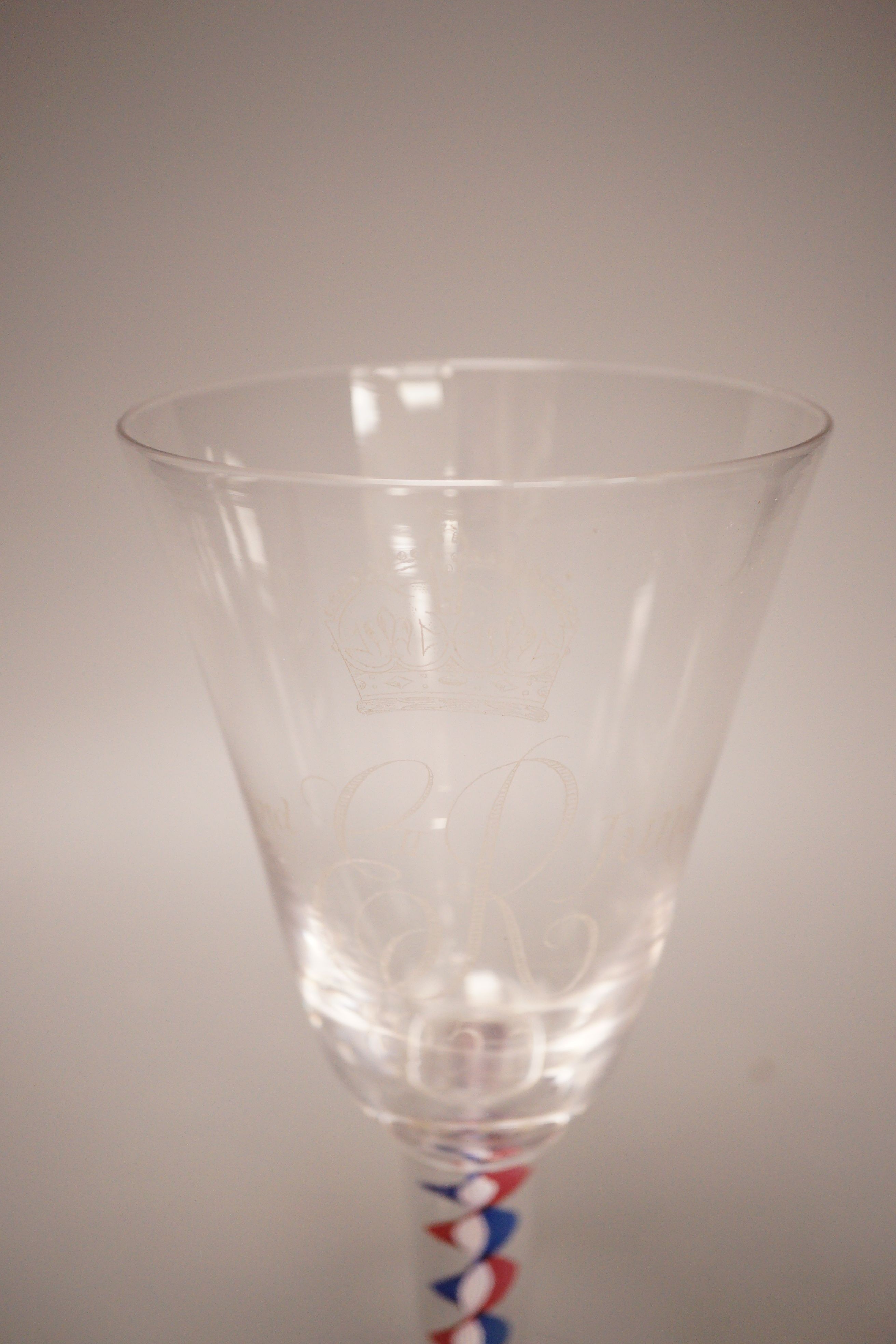 A mid 18th century drawn trumpet ale glass with air tear, a George III d.s.o.t. wine glass (a.f.) and a Whitefriars 1953 coronation colour twist wine glass